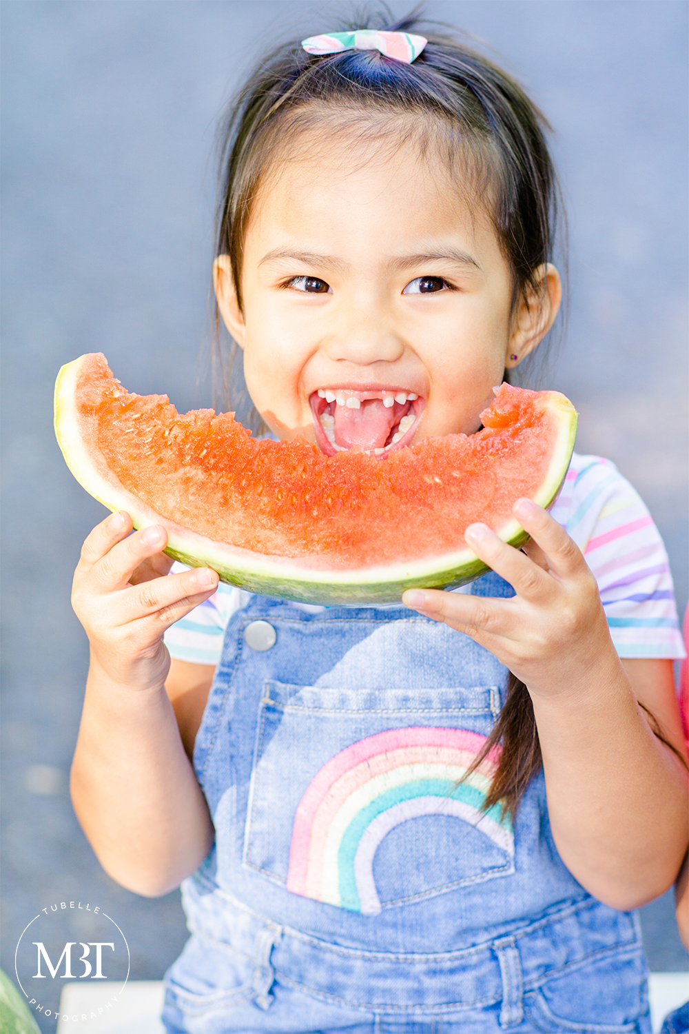 summer watermelon mini session of a girl dressed in denim overalls, eating watermelon, taken in Ellanor Lawrence Park in Chantilly, Virginia by TuBelle Photography a children's photographer in Northern Virginia