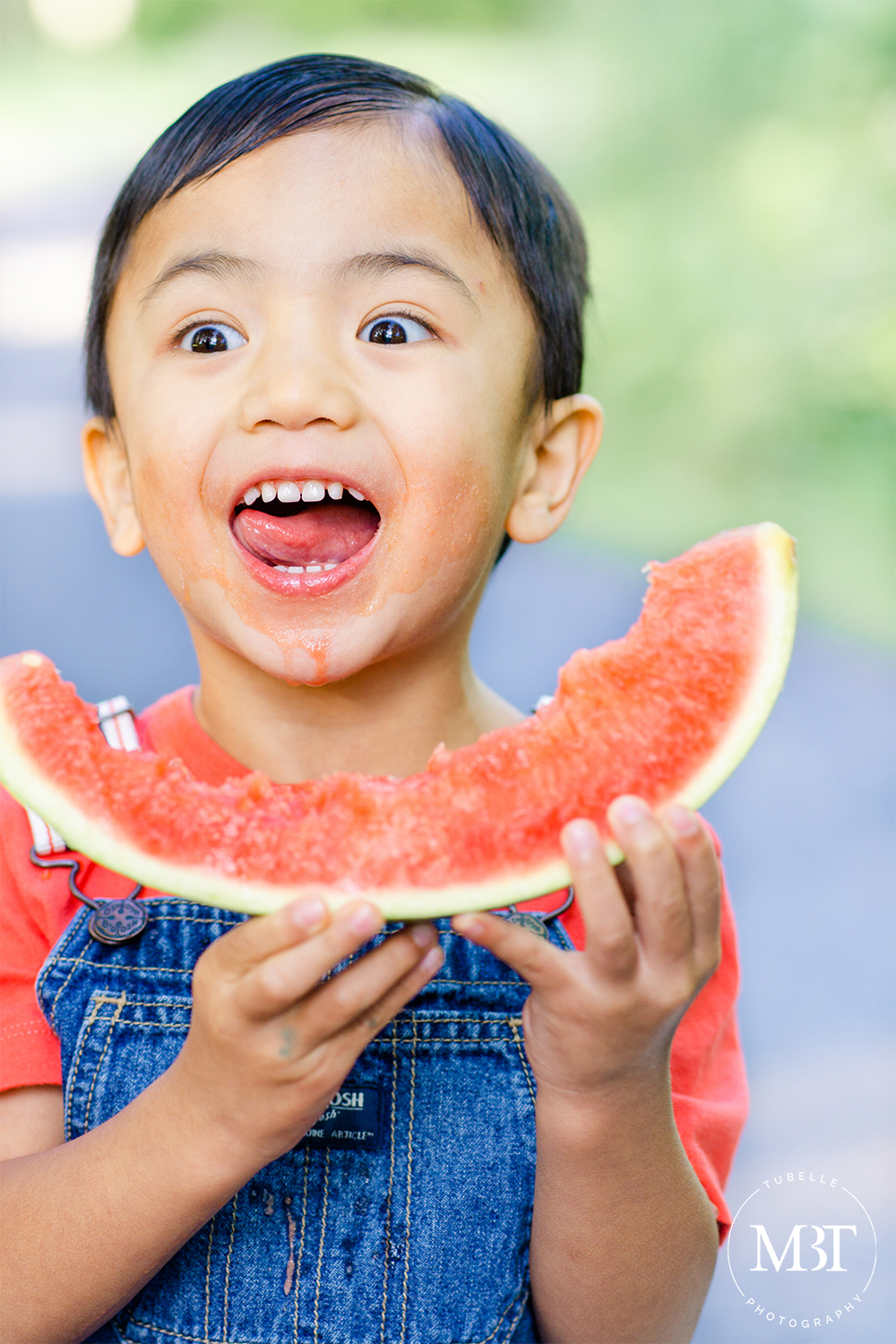 summer watermelon mini session of a boy dressed in denim overalls, eating watermelon, taken in Ellanor Lawrence Park in Chantilly, Virginia by TuBelle Photography a family photographer
