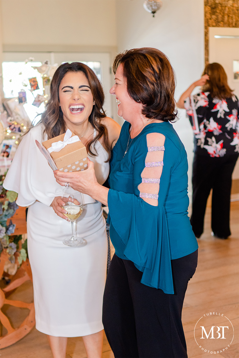 bride to be laughing with a guest during games, taken in Waterford, Virginia at a bridal shower covered by an event photographer in Virginia