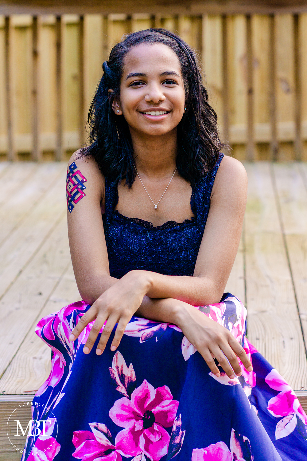 prom session - portrait of a teenage girl sitting & smiling, at a backyard in Fairfax, Virginia by a Northern Virginia portrait photographer