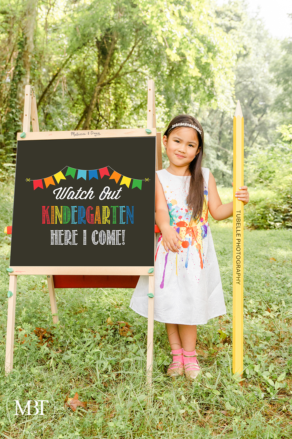 girl leaning on a blackboard while holding a giant pencil at a back to school mini session done in Northern Virginia by children's photographer in Virginia