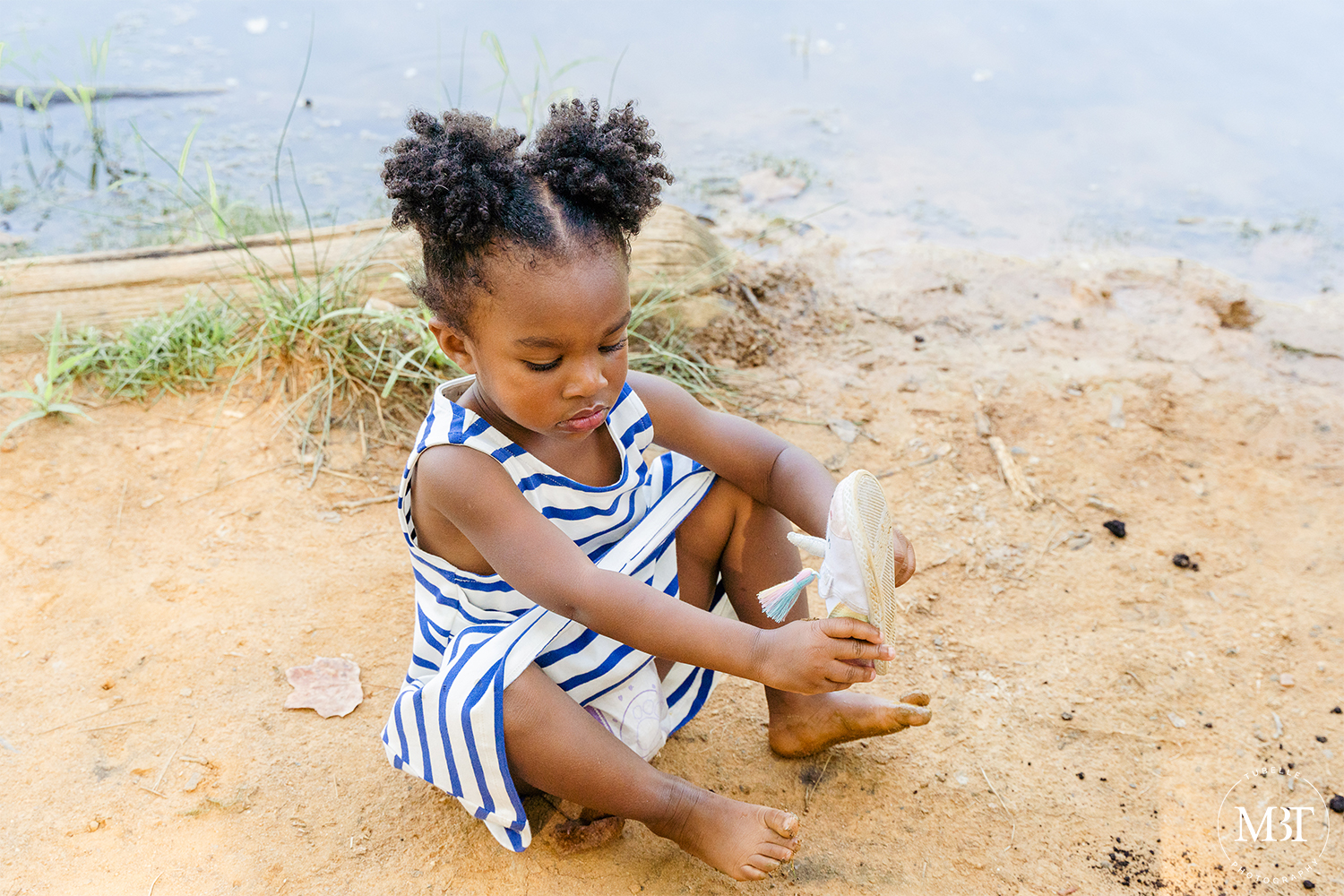 toddler putting her shoes on, taken at Triangle, Virginia by a Virginia portrait photographer
