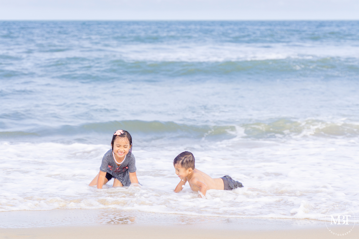 siblings playing at the beach, taken i Virginia Beach by a Northern Virginia portrait photographer