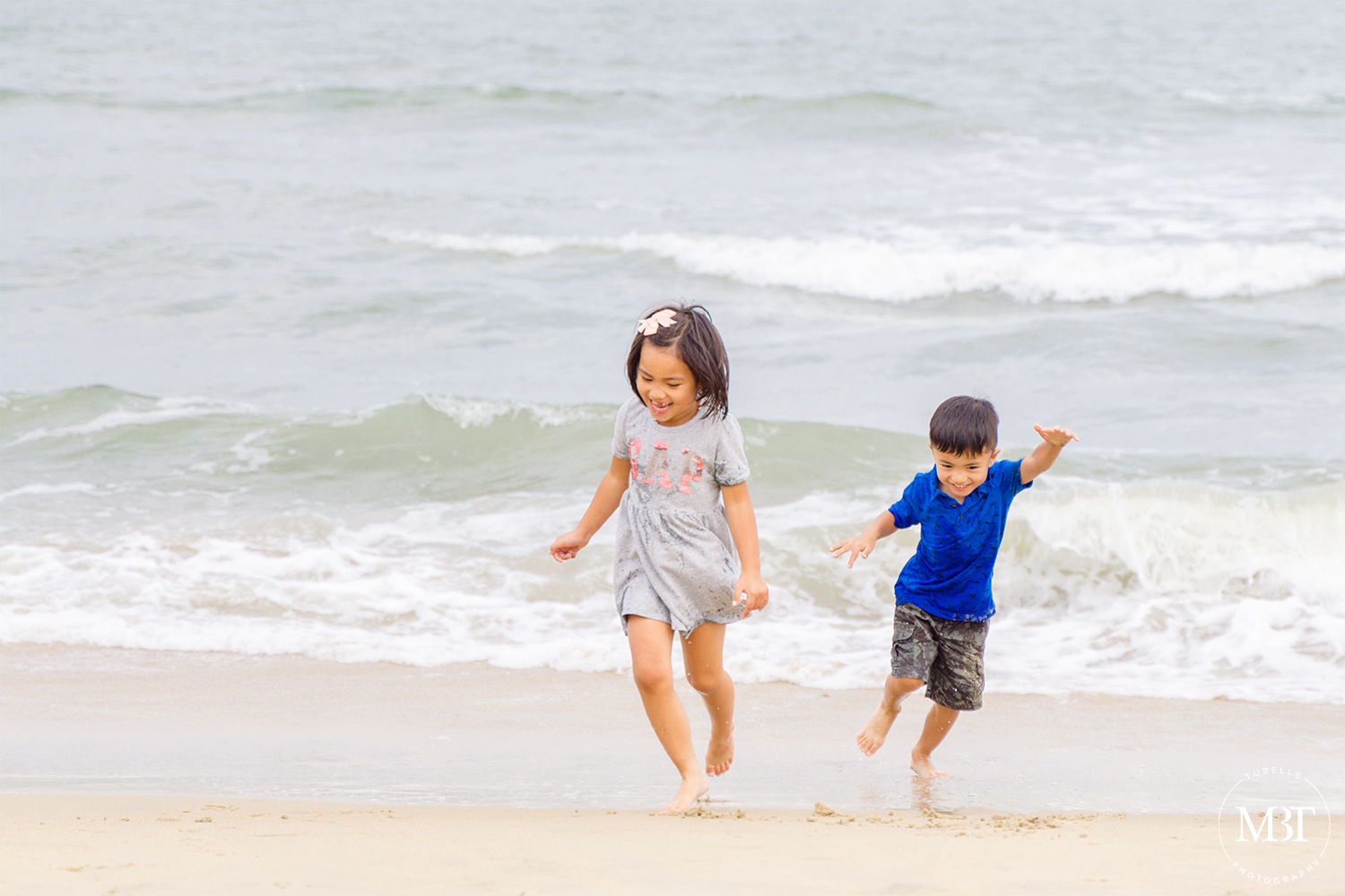 siblings running from the beach, taken in Virginia Beach by a Virginia family photographer