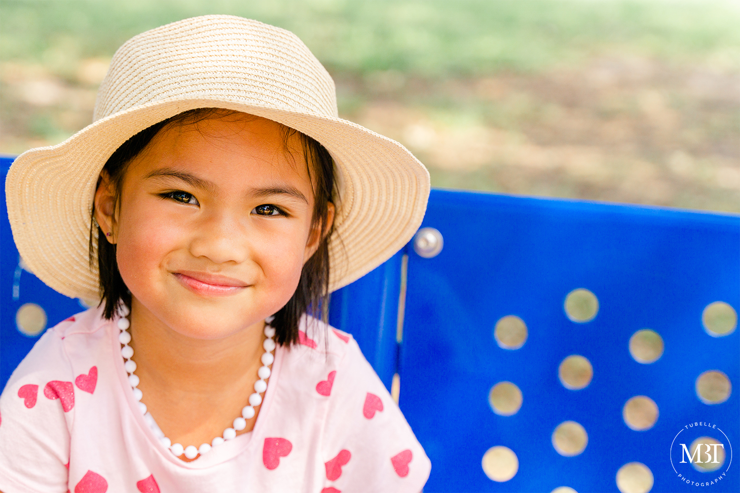portrait of a girl wearing a straw hat, taken in Virginia Zoo in Norfolk, Virginia by a Virginia family photographer
