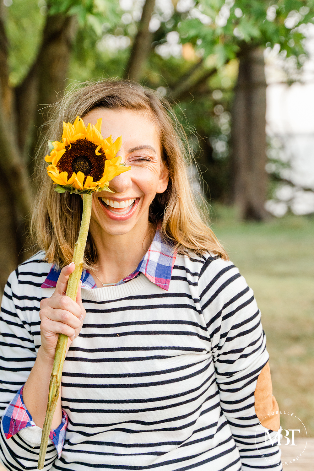 lifestyle session - fashion blogger holding a sunflower, taken at Jones Point Park by a Northern Virginia branding photographer