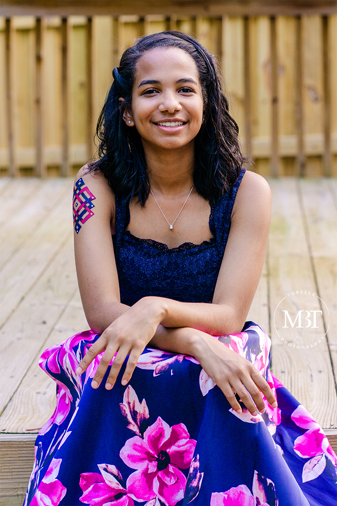 teenage girl sitting during her senior session in Bristow, Virginia by a Prince William County senior photographer