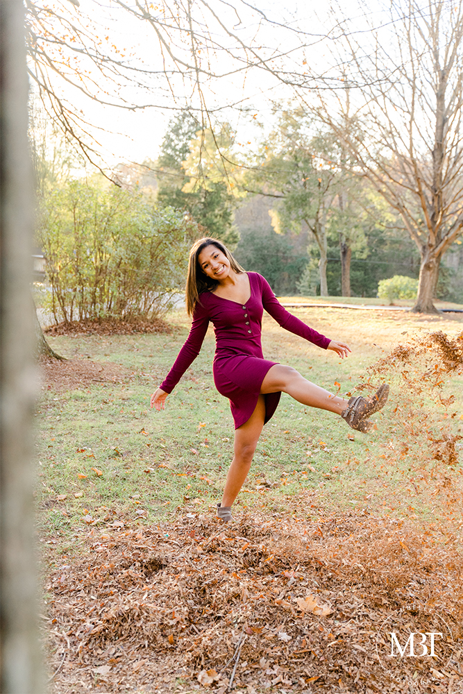 teenage girl playing with fall leaves on her senior session at Ellanor C. Lawrence Park in Chantilly, Virginia by a Virginia senior photographer