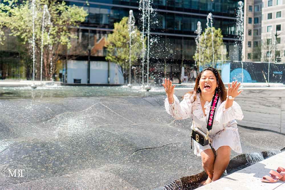 woman playing at the fountain during her personal branding session at CityCenterDC in Washington, DC by a NoVa lifestyle photographer