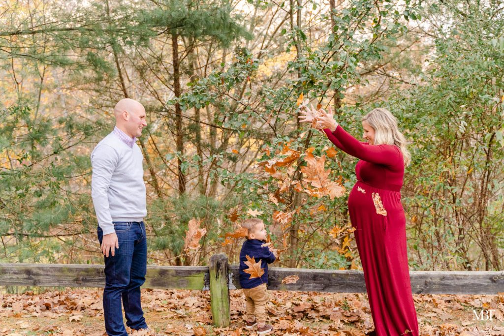 family playing with fall leaves during their family photo shoot in Woodbridge, Virginia by a Northern Virginia family photographer