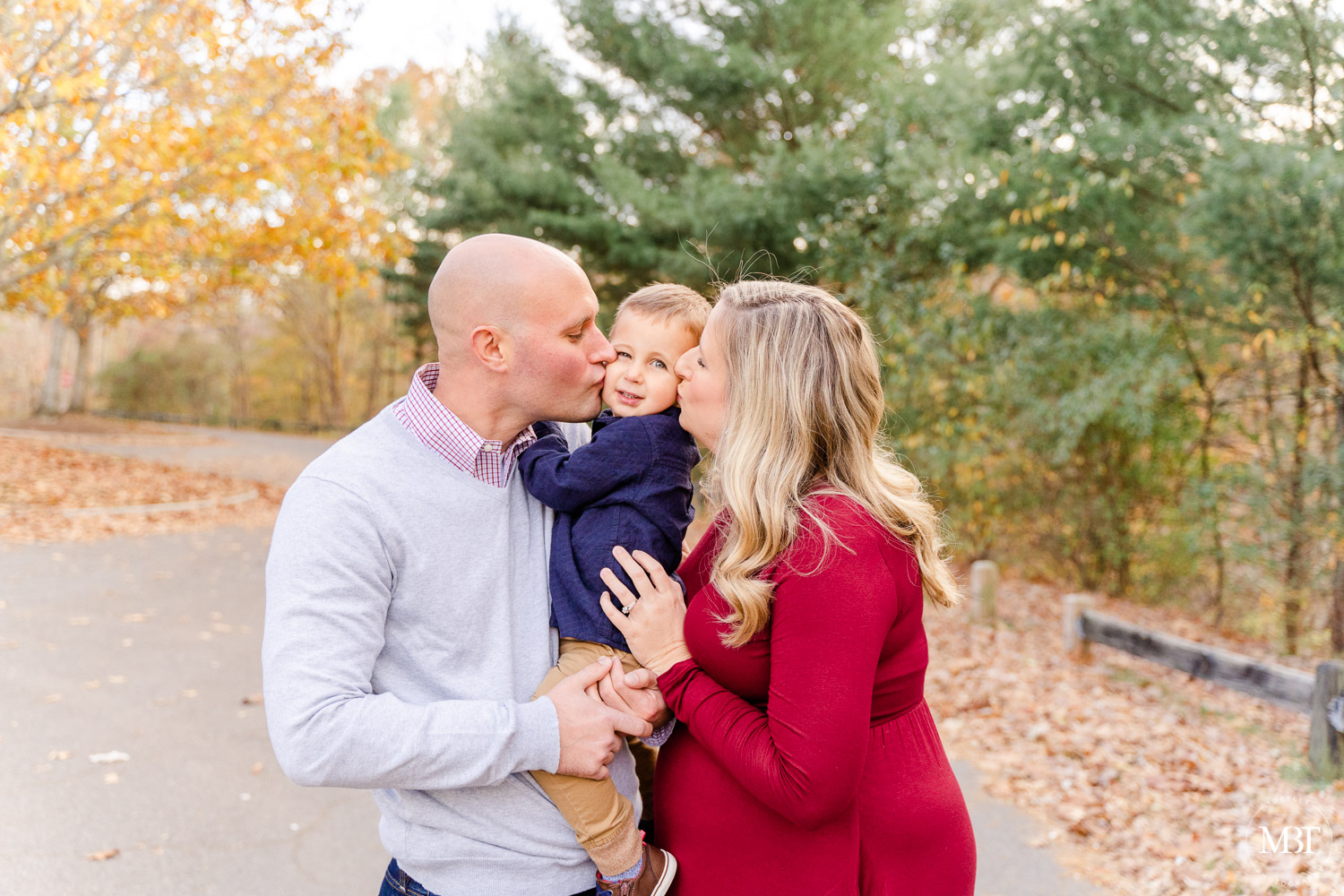 mom & dad kissing son during their family session in Woodbridge, Virginia by a Northern Virginia family photographer