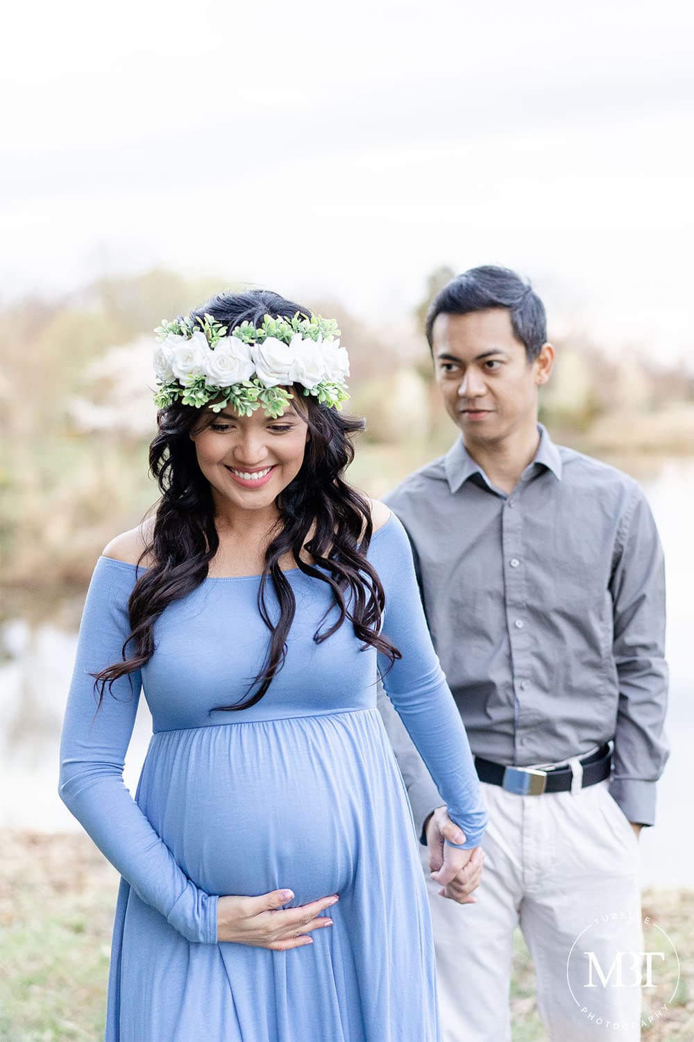 expecting couple walking while holding hands during their maternity session in Gainesville, Virginia taken by a Northern Virginia maternity photographer