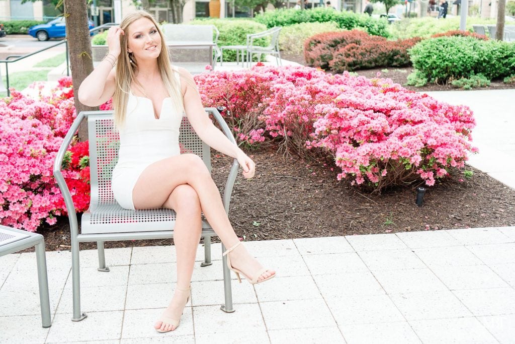 girl wearing a white dress during her senior session at Reston Town Center taken by a Gainesville, Virginia senior photographer