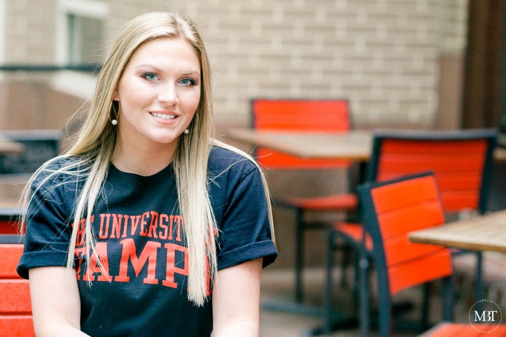 girl wearing University of Tampa tee during her senior session at Reston Town Center taken by a Northern Virginia senior photographer