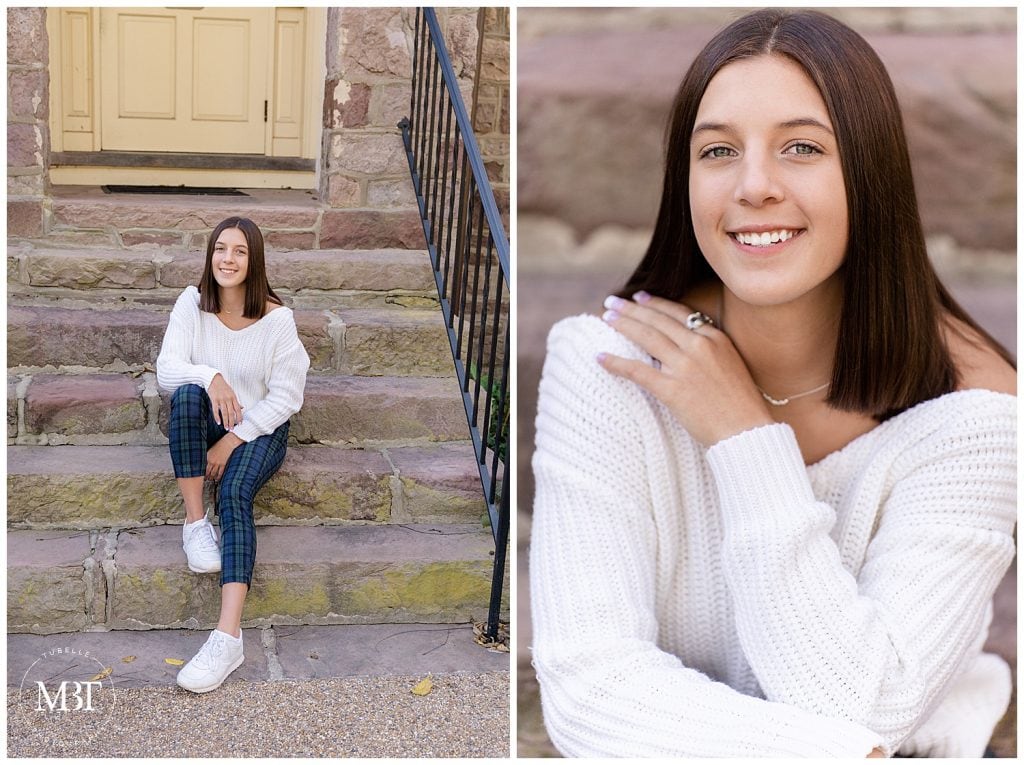 girl wearing a white sweater, and plaid pants sitting by the stairs during her senior session in Chantilly, Virginia, taken by TuBelle Photography, a Virginia senior photographer