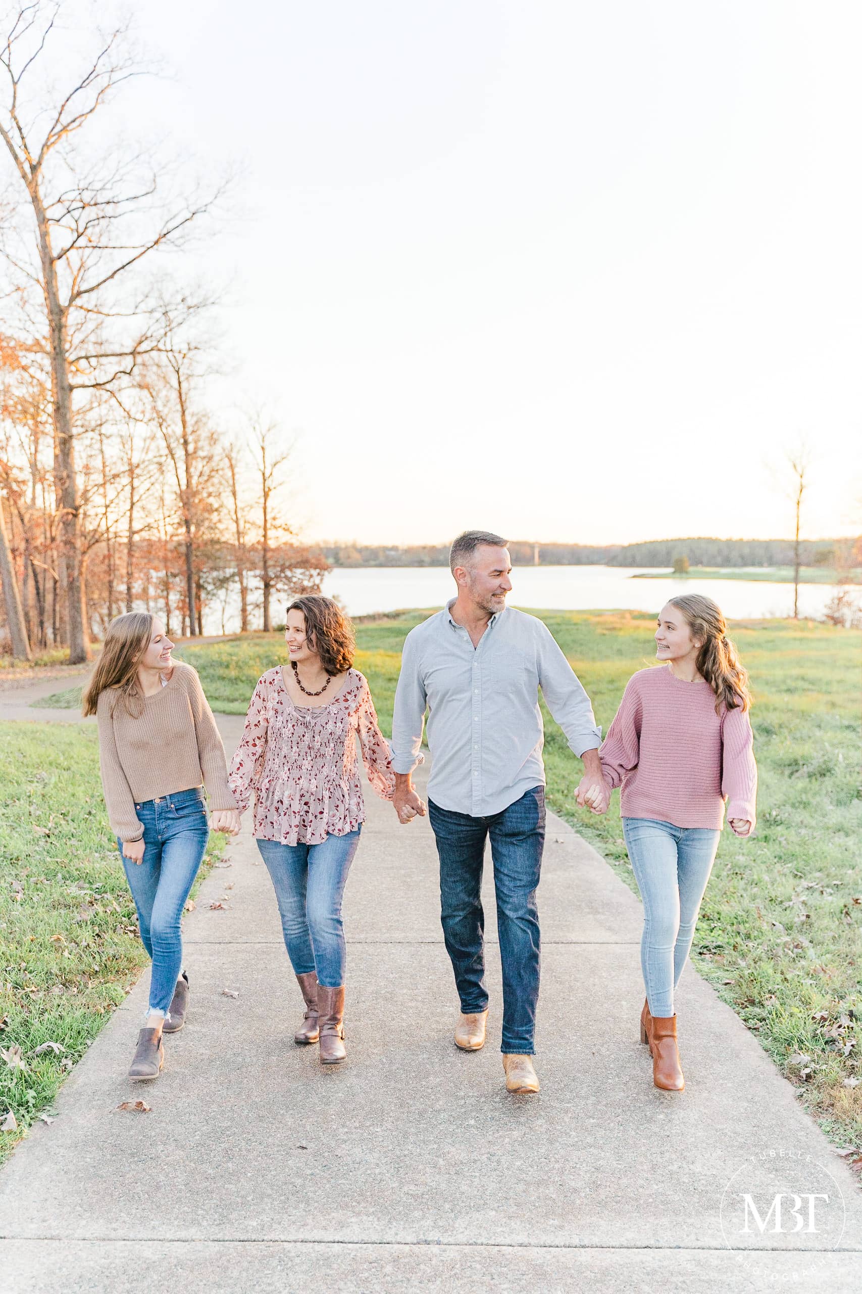 mom, dad, & daughters walking during family photography in Manassas, Virginia, taken by TuBelle Photography, a Virginia family photographer