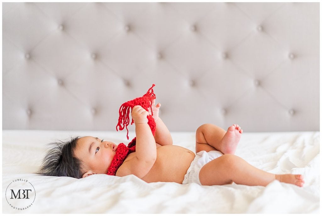 baby boy wearing a red scarf during his milestone baby photo shoot in Mclean, Virginia by TuBelle Photography, a baby photographer in NoVa