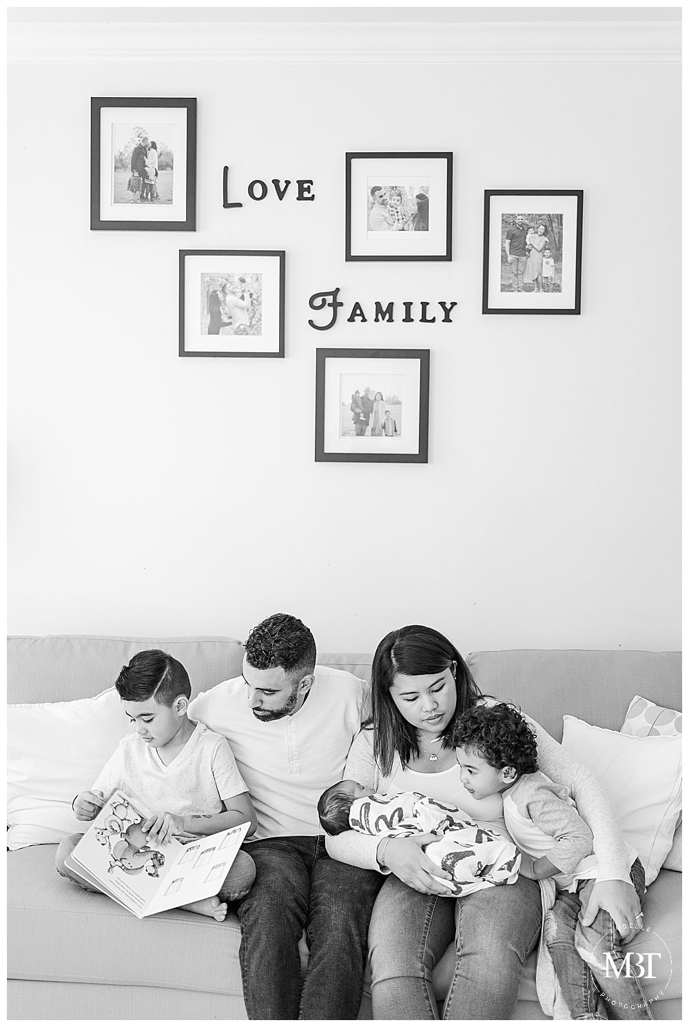 family of 5 reading a book to baby girl during their in home newborn photography in Gainesville, Virginia, taken by TuBelle Photography, a Northern Virginia newborn photographer