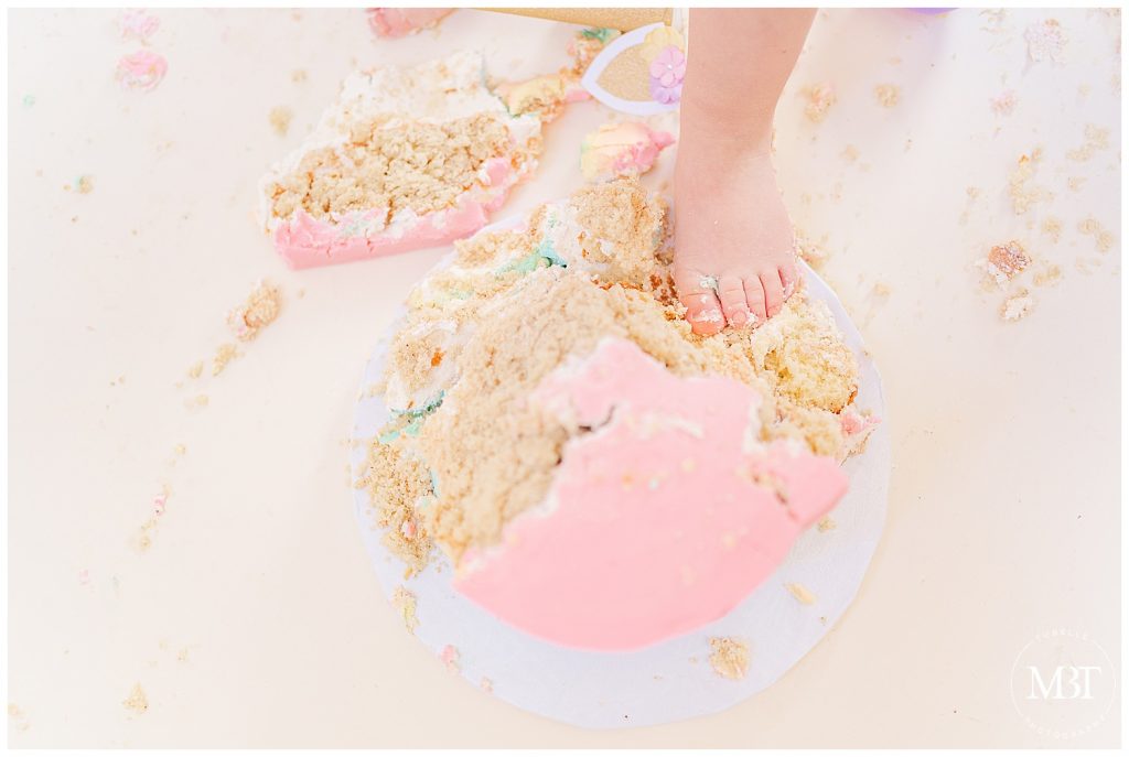 foot on cake during cake smash pictures in Gainesville, Virginia taken by TuBelle Photography, a Northern Virginia cake smash photographer