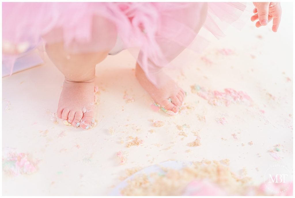 feet on cake crumbs on the floor during cake smash photography in Gainesville, Virginia taken by TuBelle Photography, a Prince William County cake smash photographer