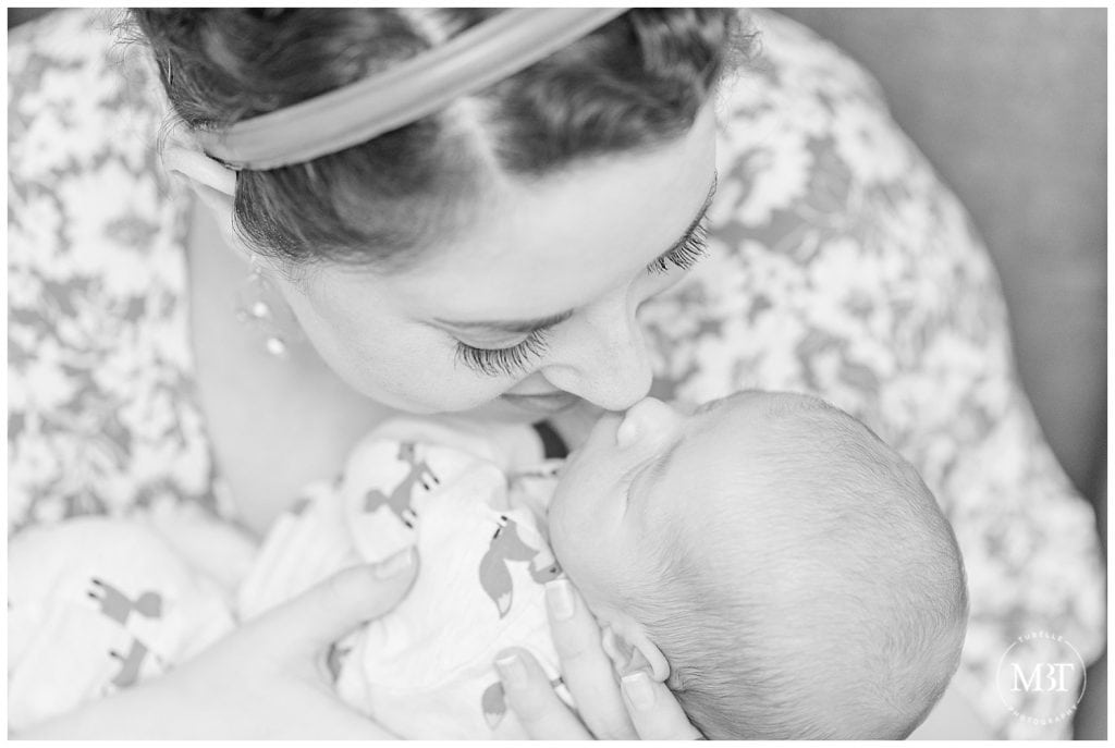 Black and white image of mom and newborn baby boy touching noses, taken by TuBelle Photography, a Northern Virginia Lifestyle Newborn Photographer.