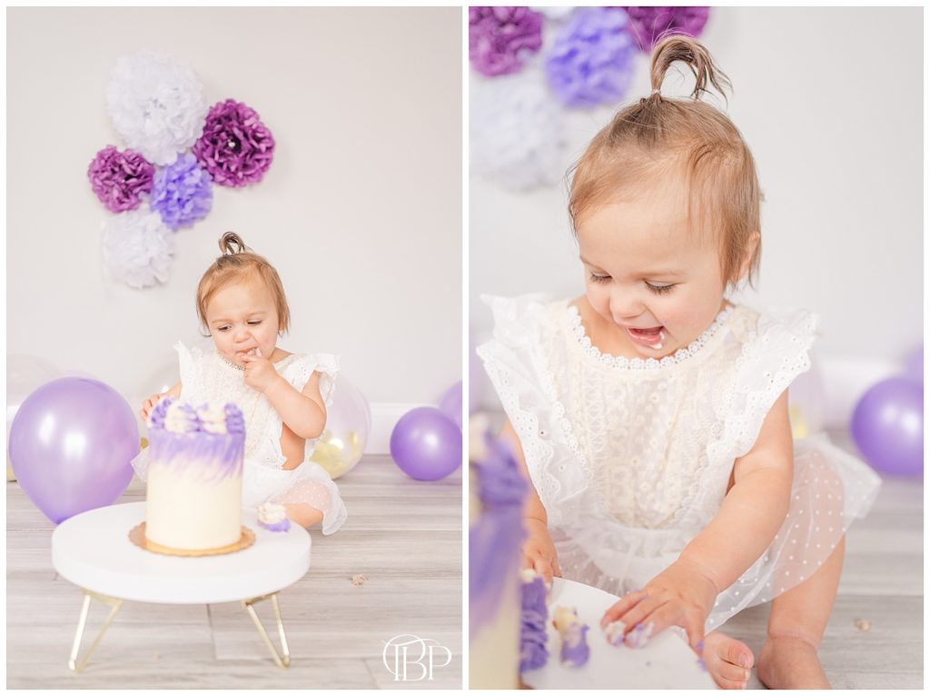 Little girl in beige, lace onesie putting fingers into cake for cake smash pictures. Taken by TuBelle Photography, a Fairfax County, Virginia lifestyle photographer.