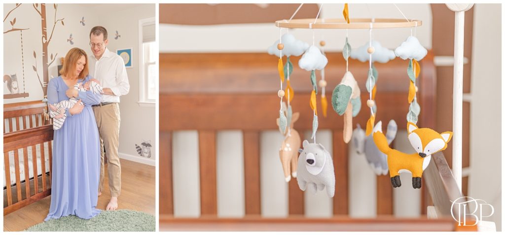 Forest themed baby mobile over baby's crib and mom and dad looking down at newborn baby boy for their in home newborn pictures in Reston, Virginia. Taken by TuBelle Photography, a Fairfax County, Virginia newborn photographer.