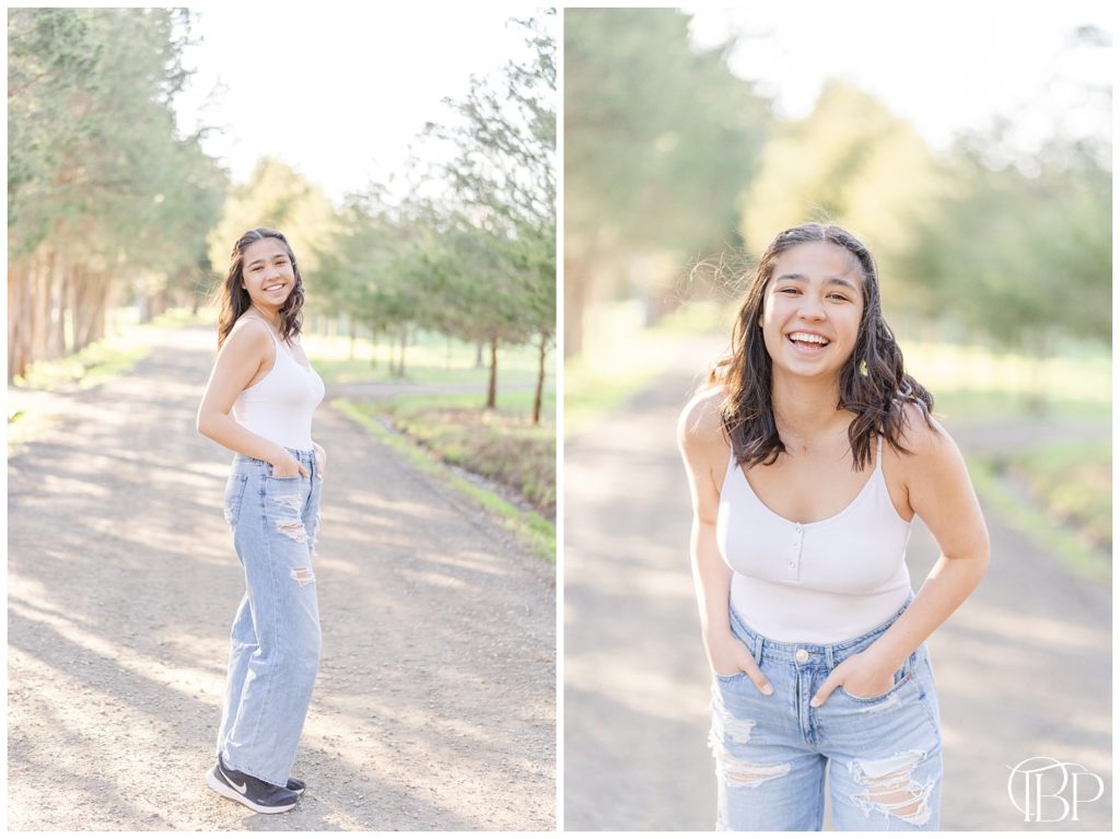 Senior girl in white tank top and jeans posing with hands in her pocket on a road for her Claude Moore Park senior photos taken by TuBelle Photography, a Northern Virginia Senior Photographer.