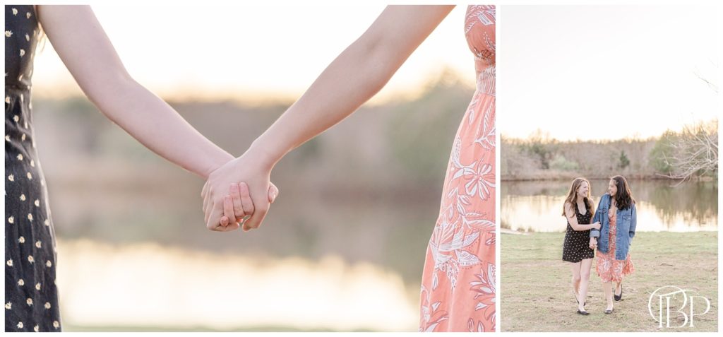 Senior girl holding hands in the air with her best friend by a pond for her Claude Moore Park senior photos taken by TuBelle Photography, a Sterling, VA Senior Photographer. 