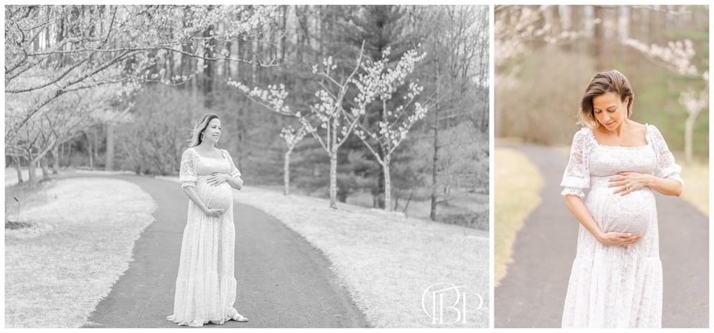 Black and white photo of mom standing alone, holding her baby bump for her  maternity portraits at Meadowlark Botanical Gardens in Vienna, Virginia. Taken by TuBelle Photography, a Fairfax County, VA maternity photographer.