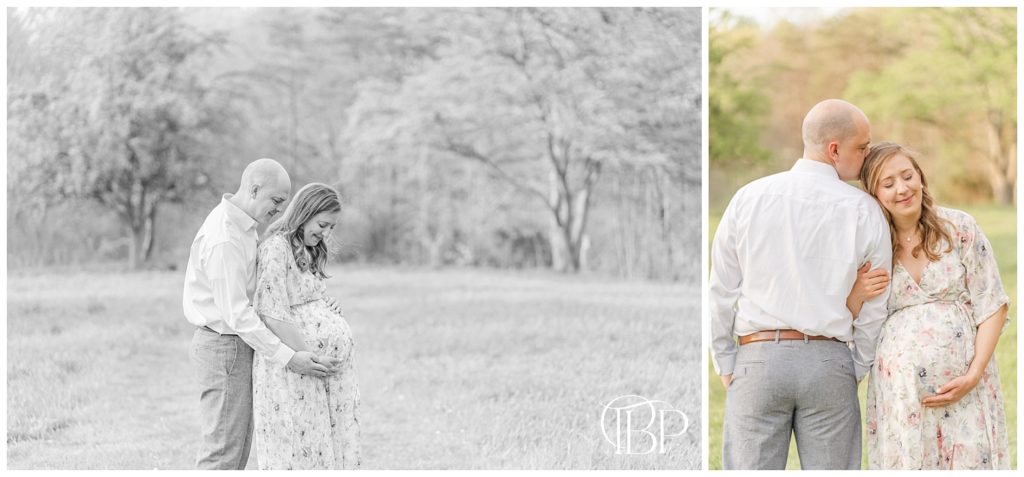 Black and white photo of expecting mom and dad looking lovingly down at her baby bump and dad kissing mom on the head for their maternity pictures in Fairfax County, Virginia. Taken by TuBelle Photography, a DMV maternity photographer.