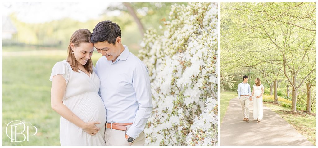 Expecting mom and dad looking down at baby bump and holding hands while walking together for their maternity pictures with tons of flowers in Vienna, VA taken by TuBelle Photography, a Fairfax County, Virginia maternity photographer.
