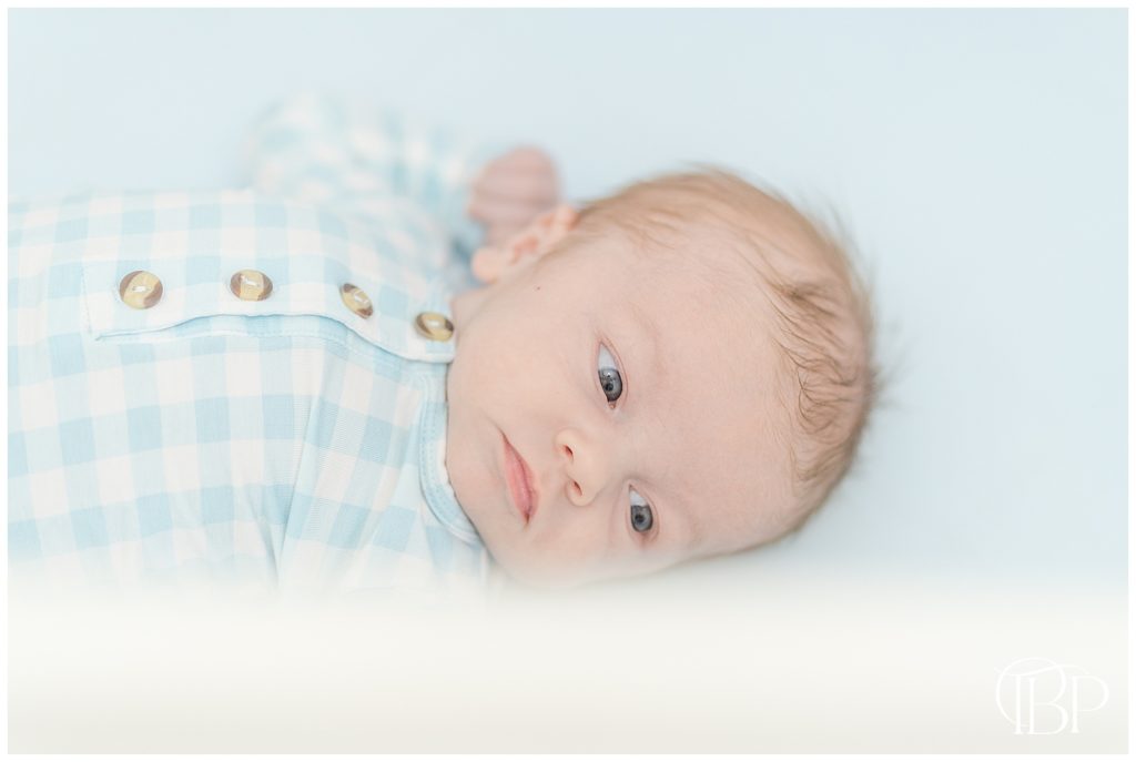Baby boy lying in crib for lifestyle newborn session in Alexandria, Virginia. Taken by TuBelle Photography, a newborn photographer.