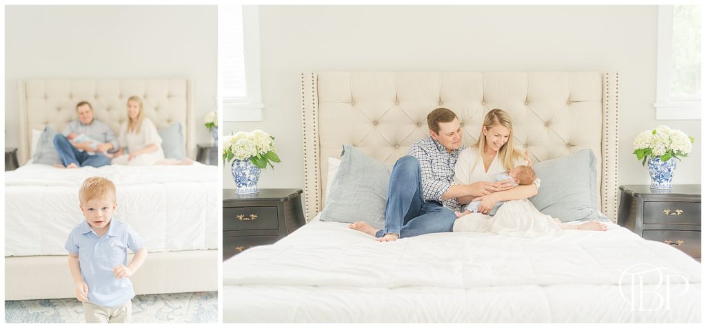 Big brother running in master bedroom while mom and dad hold newborn baby boy on bed for newborn photos taken by TuBelle Photography, an Alexandria, Virginia newborn photographer.