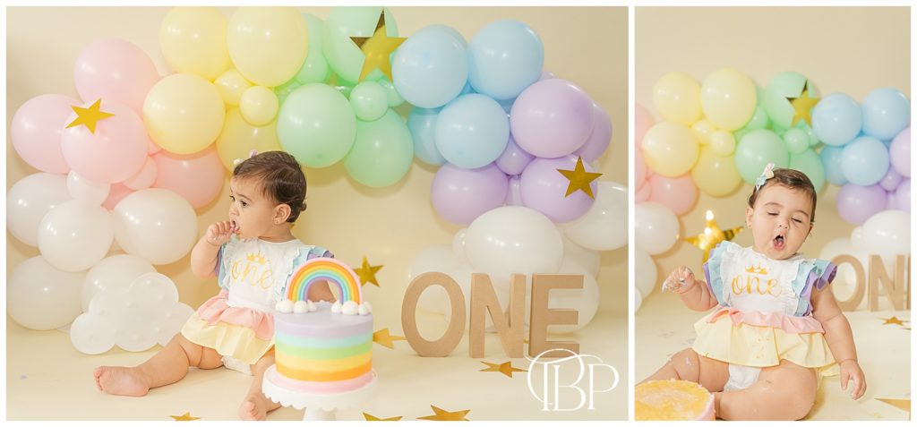 Baby girl eating cake for her rainbow themed cake smash session. Taken by TuBelle Photography, a Fairfax County, VA cake smash photographer.