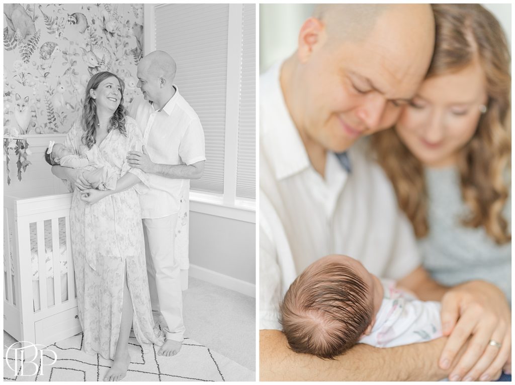 Mom and dad holding baby girl, looking down at her in the nursery for their lifestyle newborn photos in Centerville, Virginia taken by TuBelle Photography.
