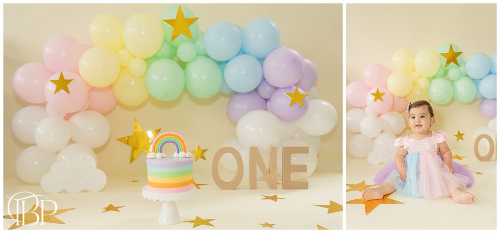 Rainbow themed cake smash set up with rainbow balloon arch and rainbow cake in Fairfax County, VA. Taken by TuBelle Photography, a cake smash photographer.