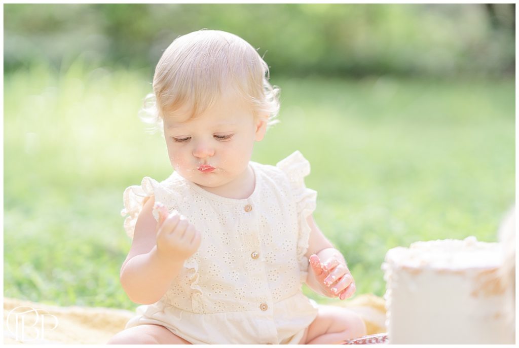 baby girl looking at her fingers during her Warrenton, Virginia cake smash photos
