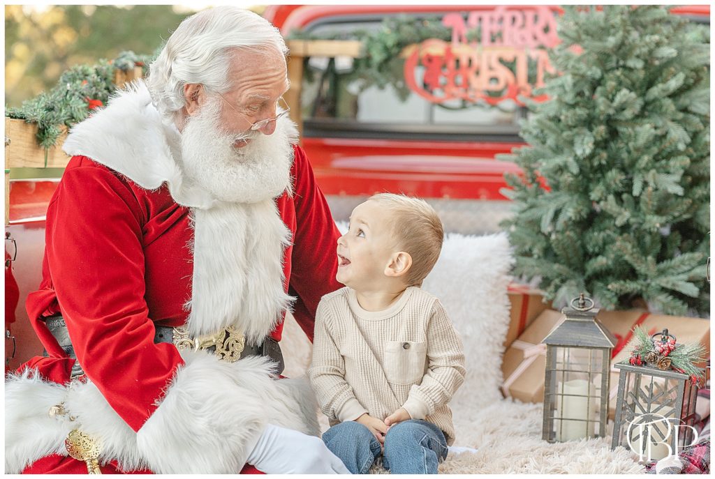 toddler excitedly talking to Santa during red truck minis taken by a Northern Virginia photographer