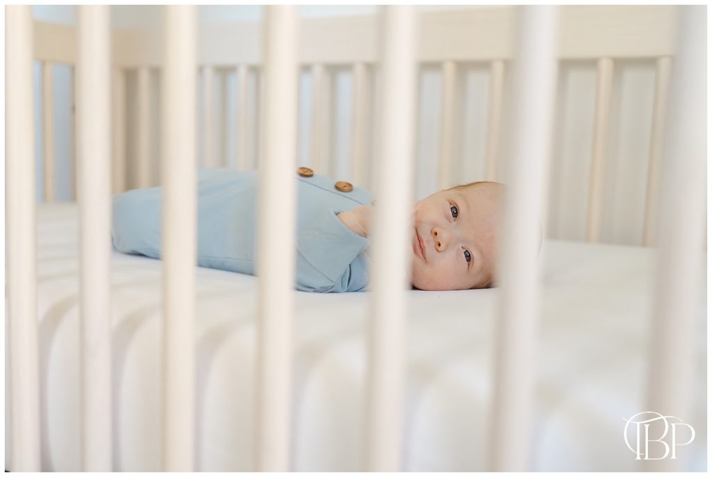 baby laying down in his crib during in home newborn photography in Arlington, Virginia