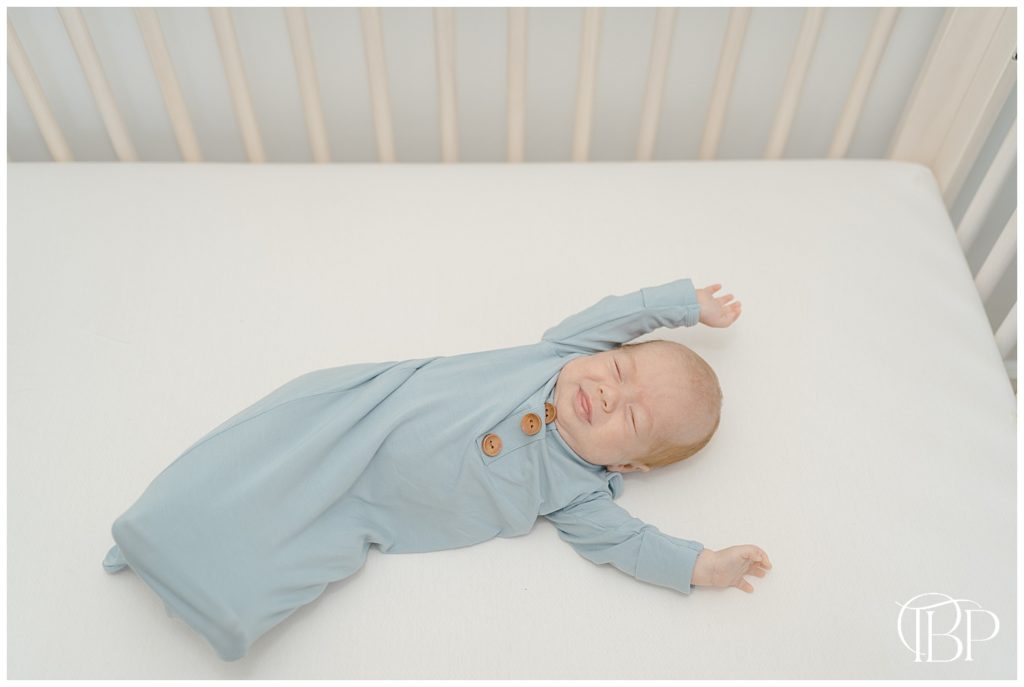 baby stretching in his crib during in home newborn photos in Arlington, Virginia
