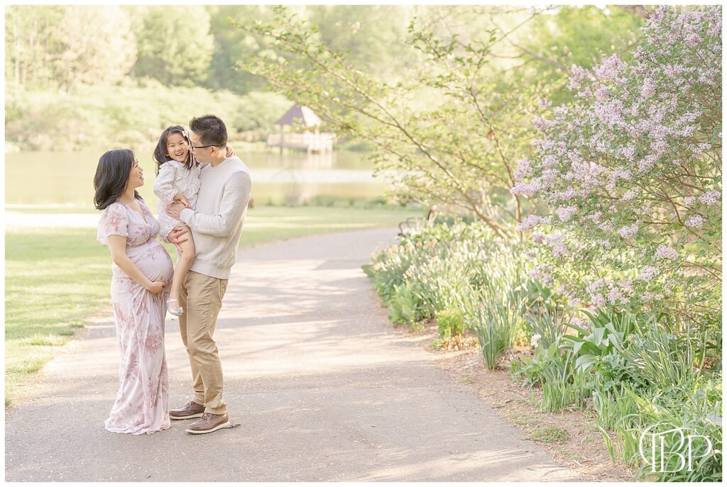 Family laughing during botanical garden maternity session in Fairfax County, VA