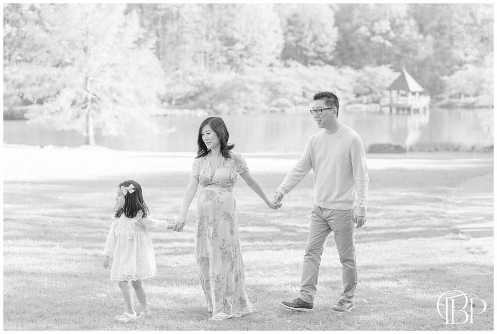 Family of 3 walking taken at a botanical garden by a maternity photographer in Fairfax County, VA