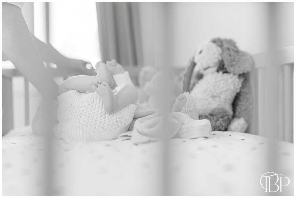 Baby feet through a crib taken during lifestyle newborn photos in Ashburn, Virginia