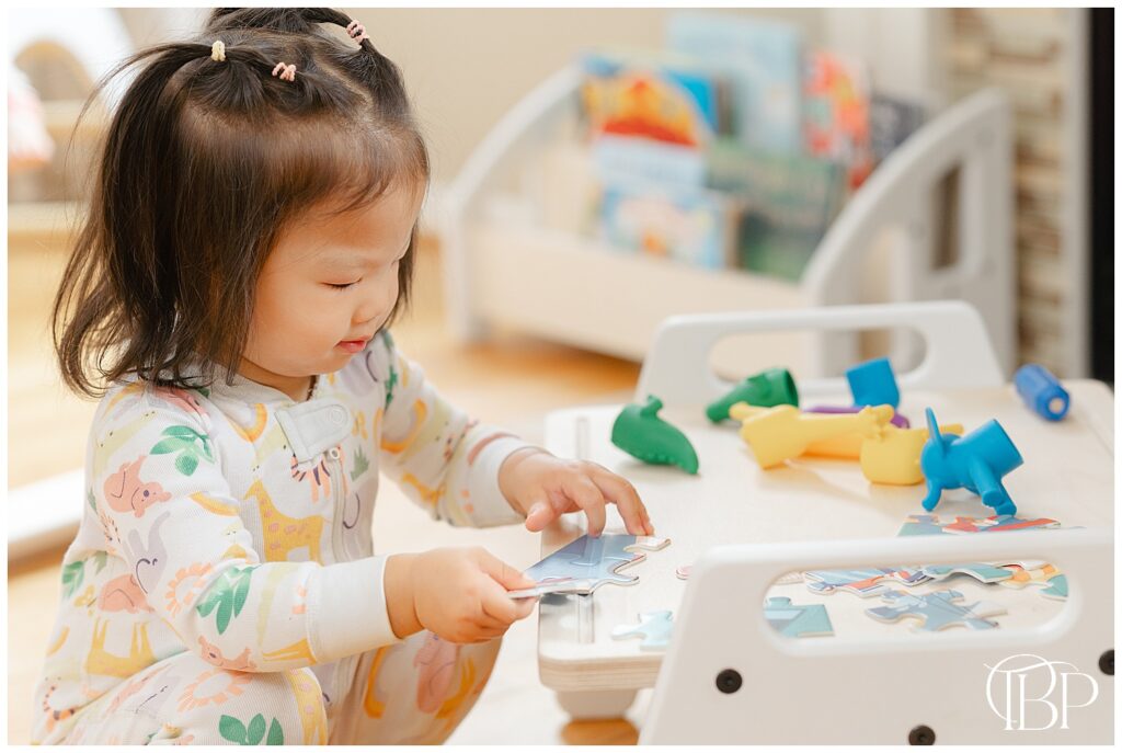 Toddler playing with puzzles on a play tray