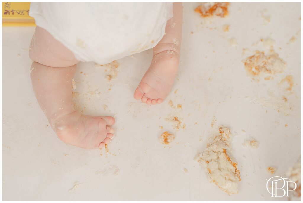 Baby's feet while crawling with tons of cake on the floor