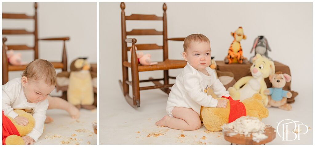 Baby playing with Winnie the Pooh during cake smash session