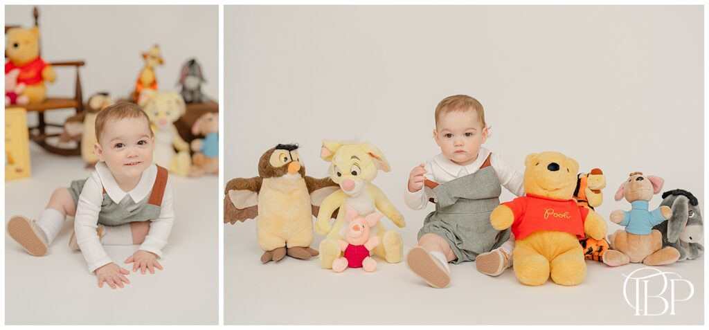 Baby sitting next to Winnie the Pooh & friends stuffed toys