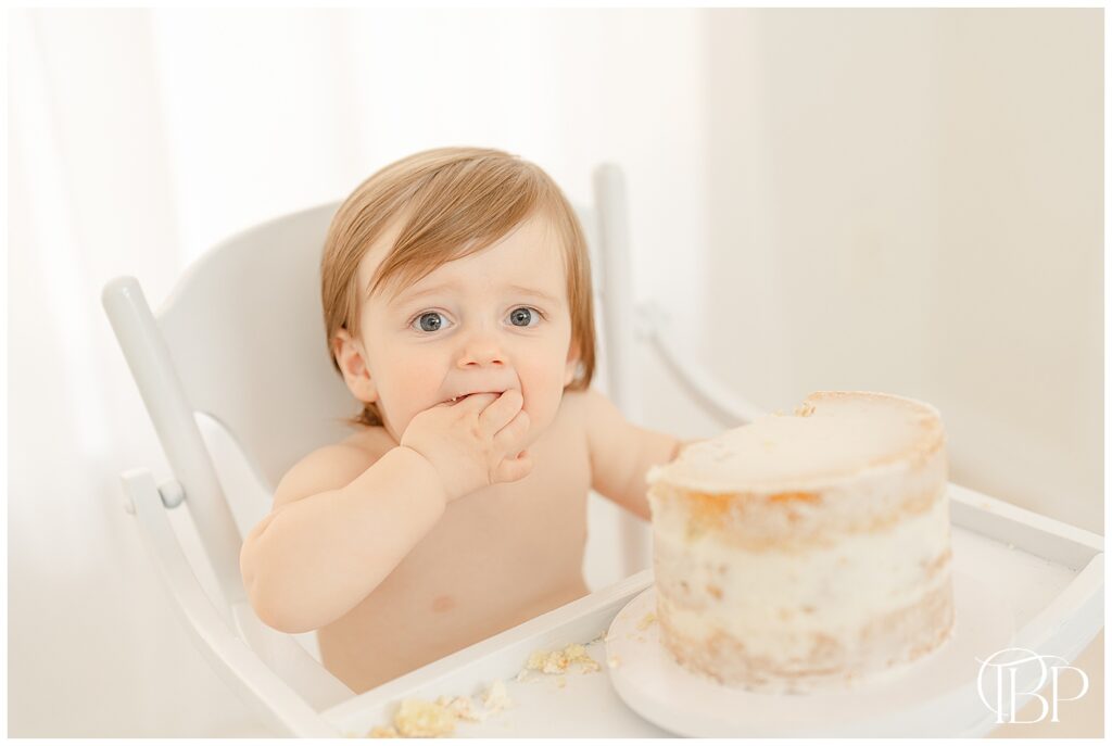 Baby eating cake during simple cake smash photos in Ashburn, VA