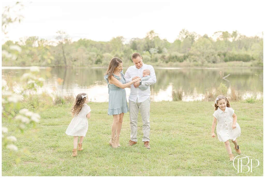 Kids run as parents play with baby during lakeside spring minis in Virginia